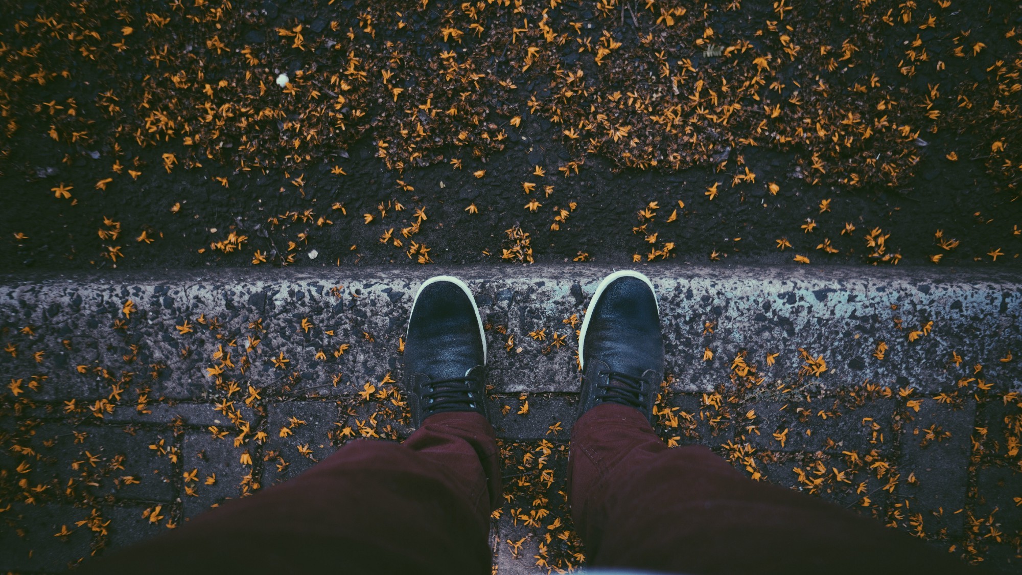 A photo of a person looking down at his shoes.