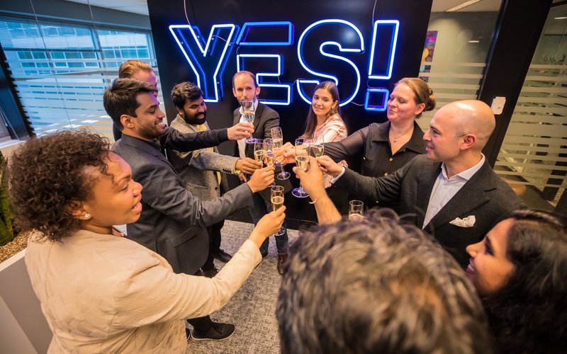 The whole Envision team celebrating milestone with some champagne in their hands