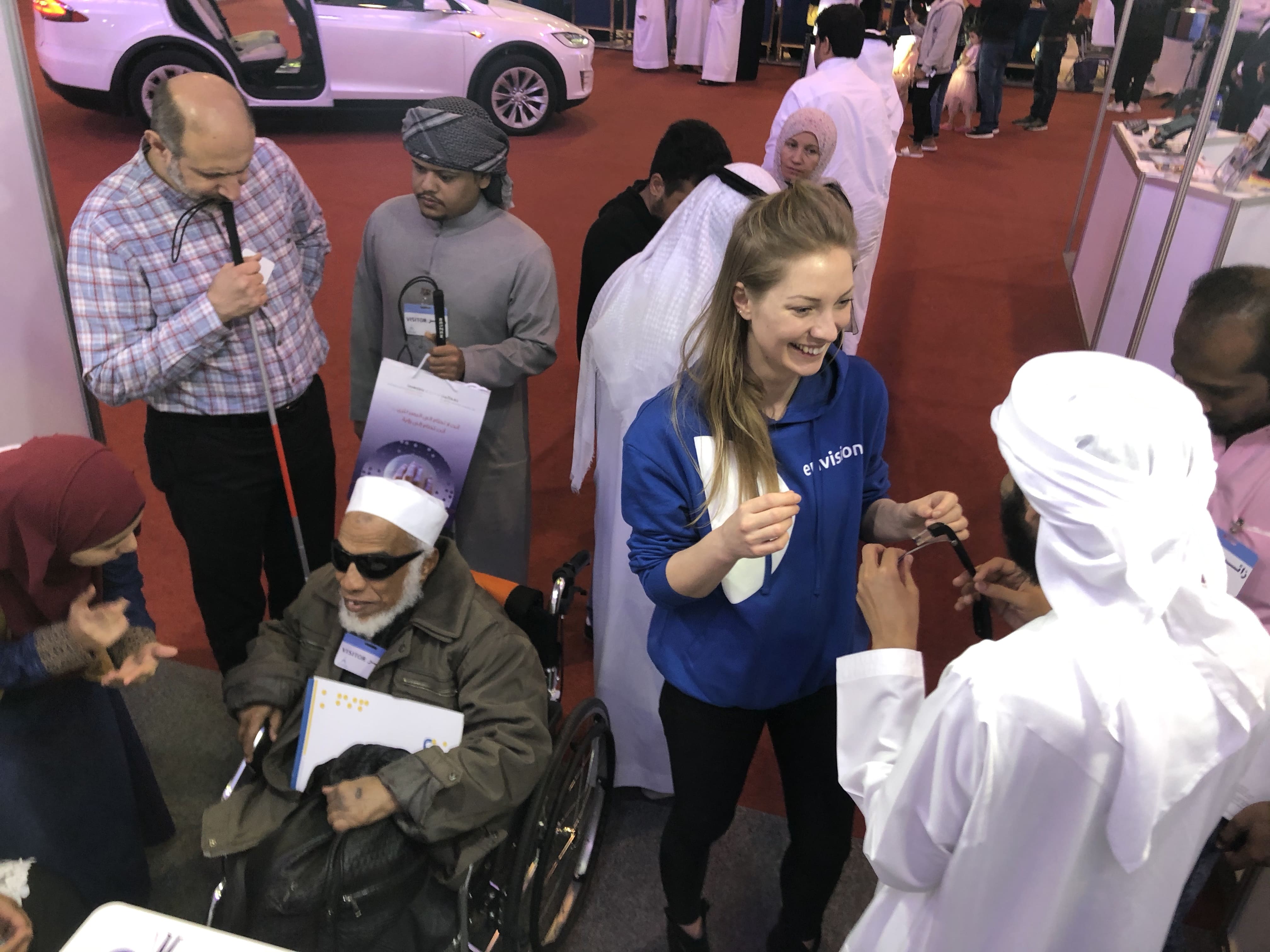 Ilse demonstrating the Envision glasses to group of visitors at an expo in Dubai