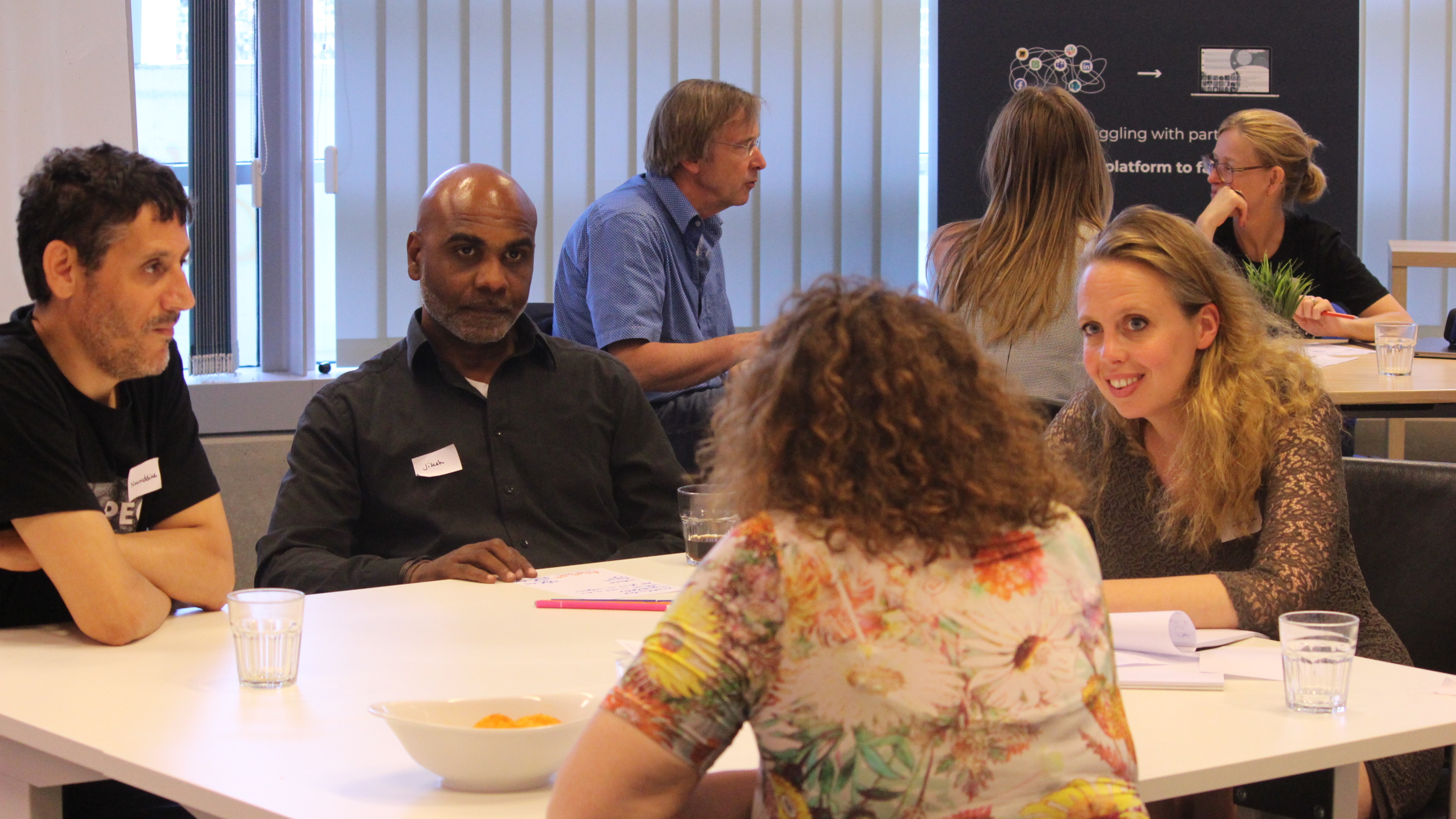 A group of people around the table talking to each other. 
