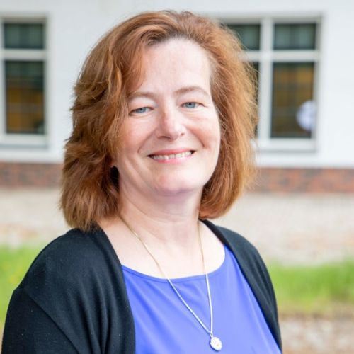 Photo of Remke Brand wearing a black cardigan and blue shirt.