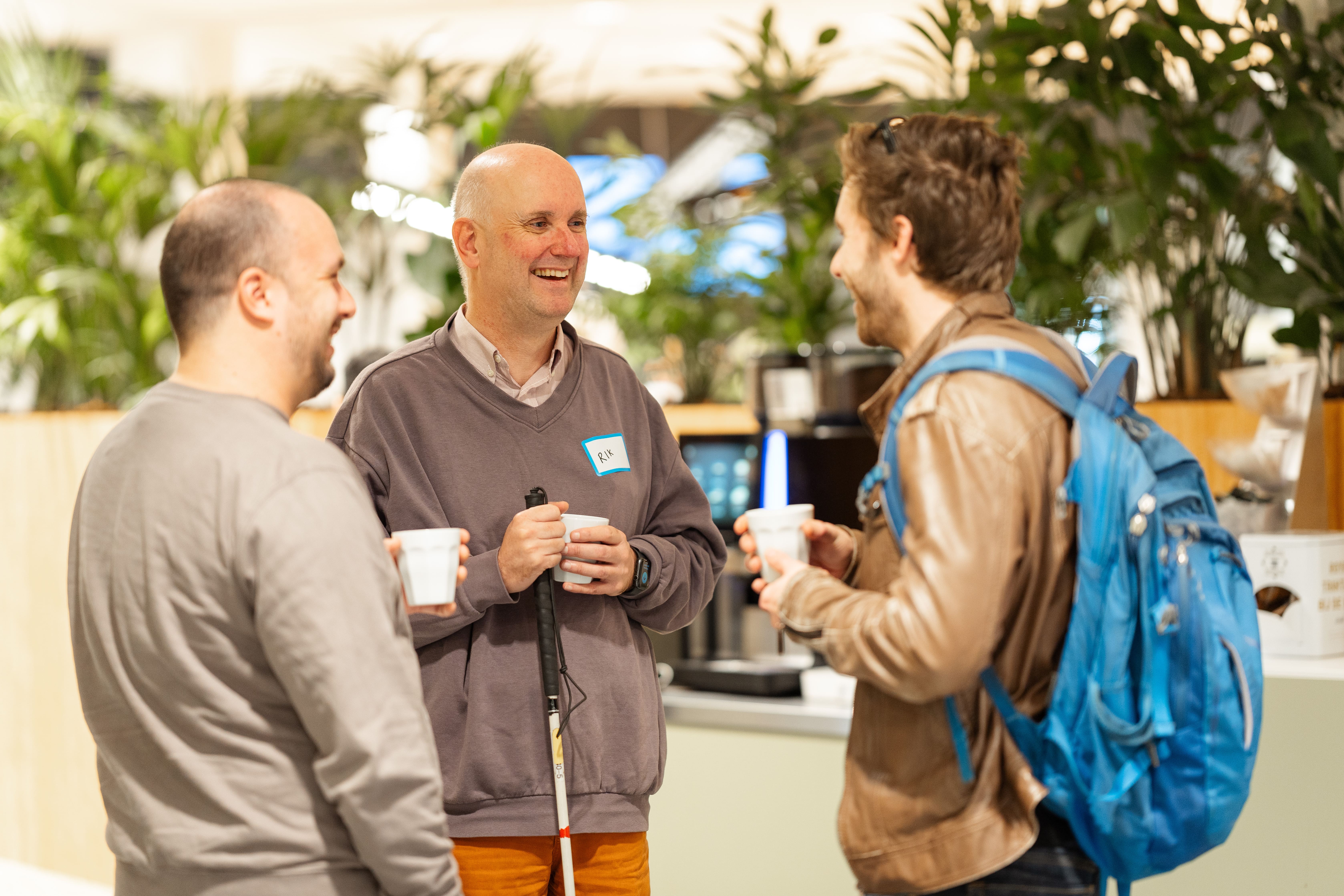 Three people talking at the moment of the drinks at the ININ event