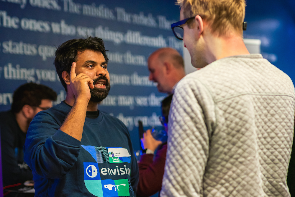 Karthik Kannan from Envision engaging with a visitor and explaining a gesture on the Envision Glasses