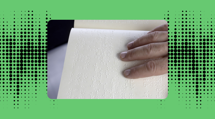 a hand touching an inscribed page in braille to read. the background is green with black dots.